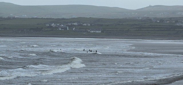 a group of beginner surfers at the north end of the beach catching whitewater
